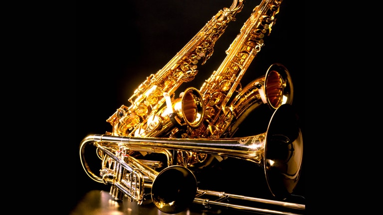Zwei Saxophone, eine Trompete und eine Posaune liegen auf dem Boden