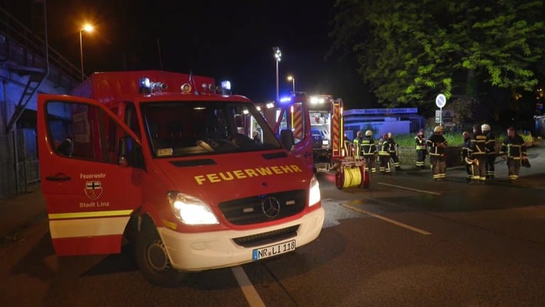 Feuerwehrleute vor einem Hotel in Linz, in dem es in der Nacht gebrannt hat.